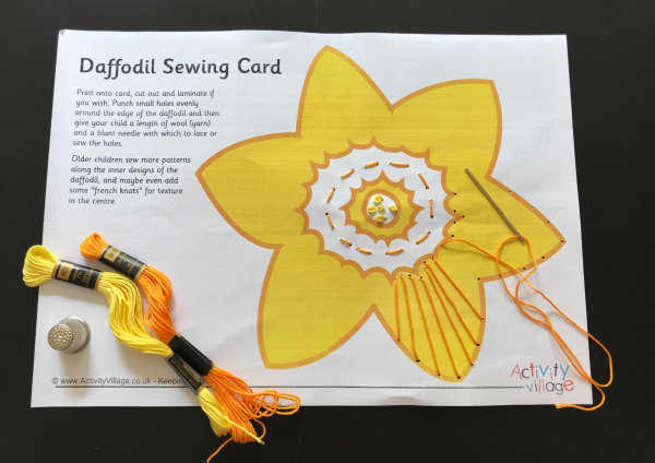 Creating a design on this daffodil sewing card with running stitch and french knots