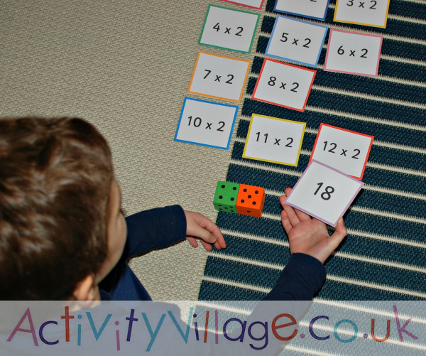 Playing a times tables game with dice and double-sided flash cards