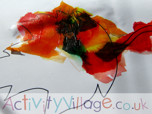 Adding tissue paper and water within the lines of the autumn leaf template