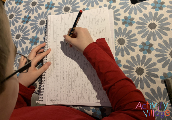 Filling in the background letters on his massive Marvel word search puzzle!