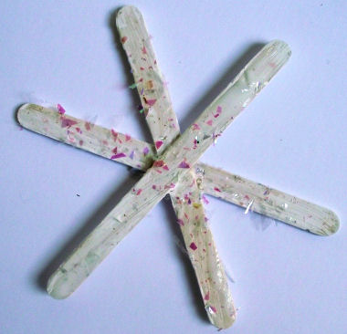 Popsicle stick snowflake craft - decorated with glittery flakes