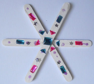 popsicle stick snowflake craft - decorated with jewels and stickers